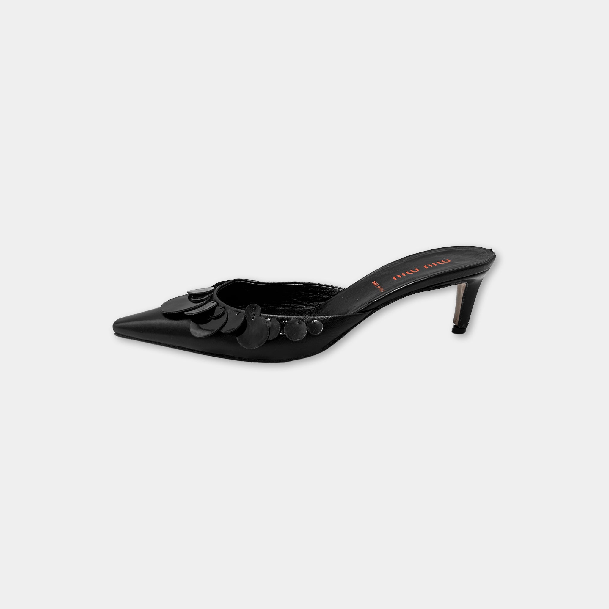 A black high-heeled shoe with a pointed toe and a pointed heel.
