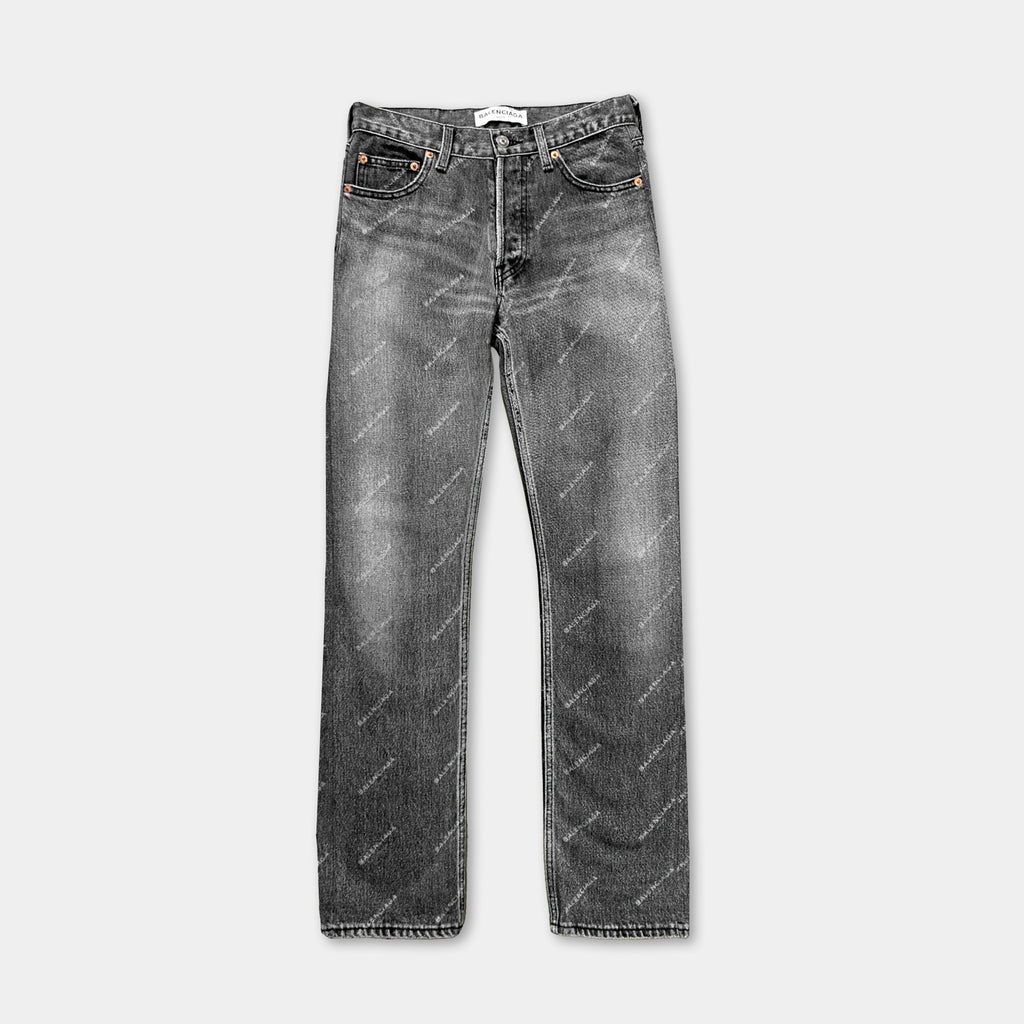 A pair of black jeans with a repeating pattern on the fabric.