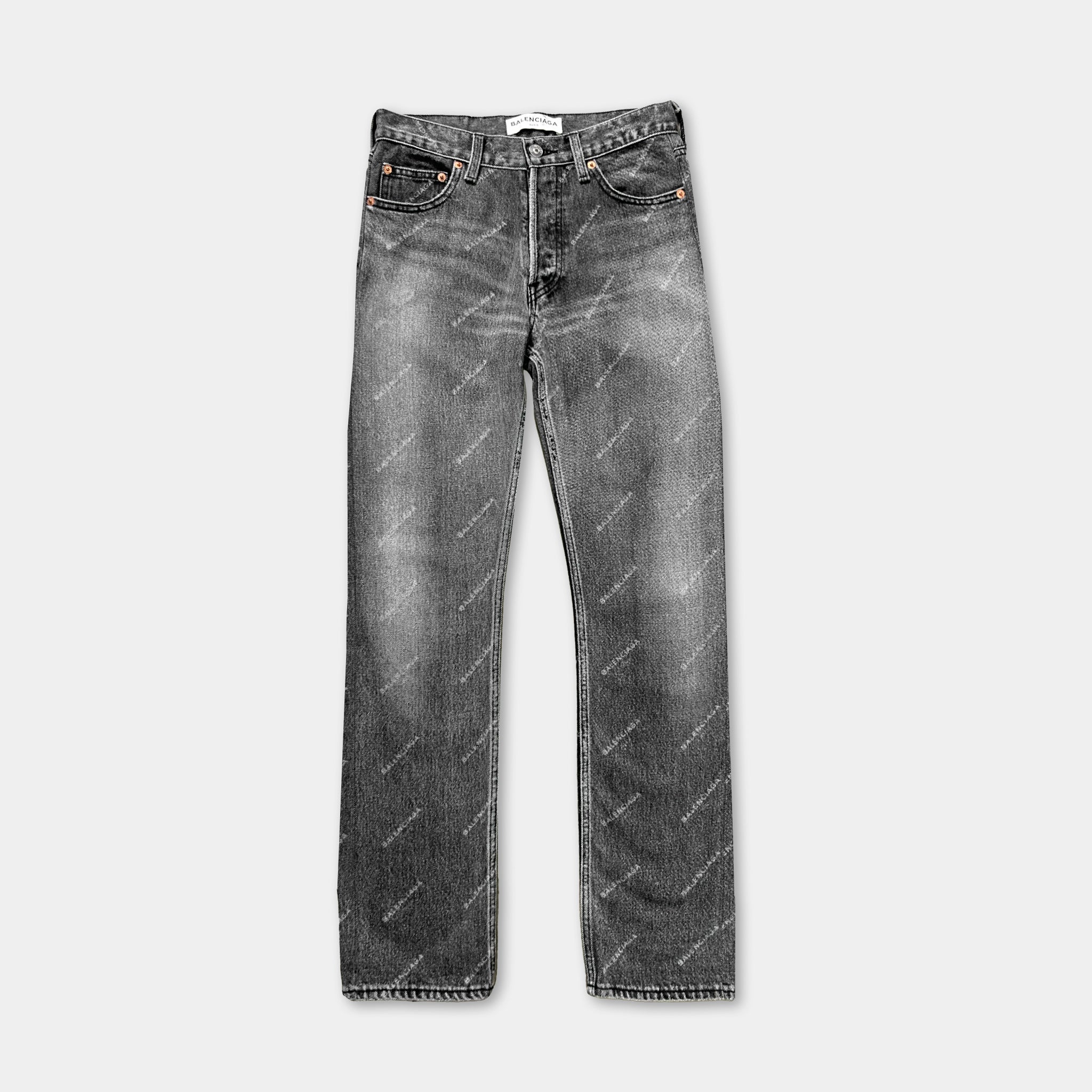 A pair of black jeans with a repeating pattern on the fabric.