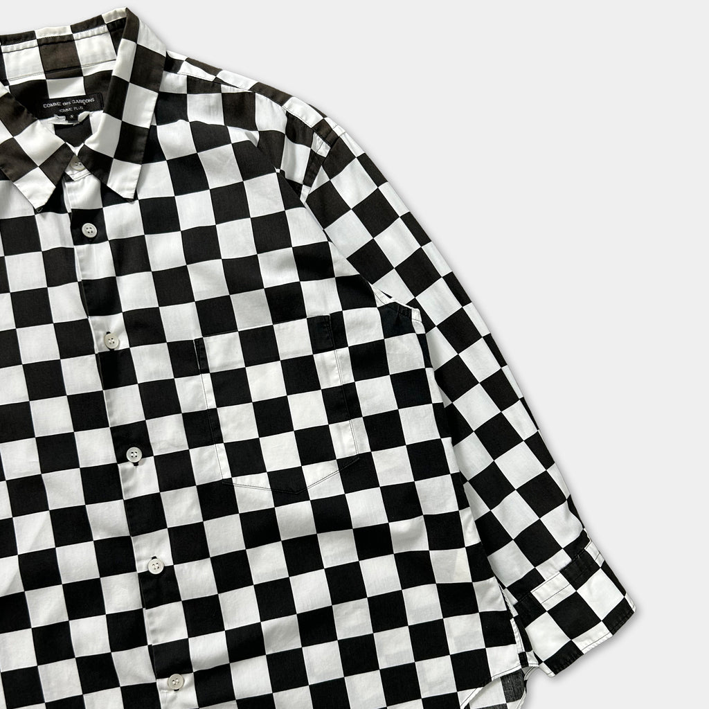 A black and white checkered shirt is displayed on a white background.