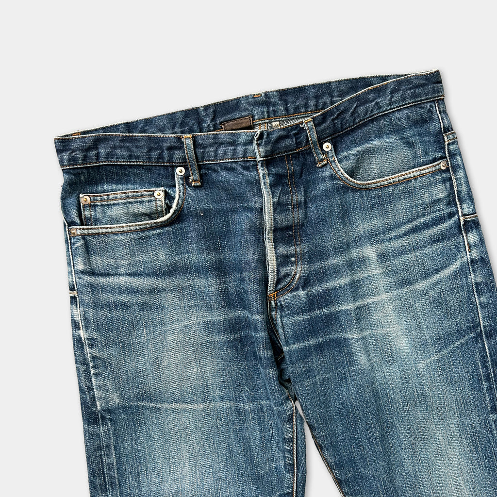 A pair of well-worn blue jeans with visible signs of use and aging.