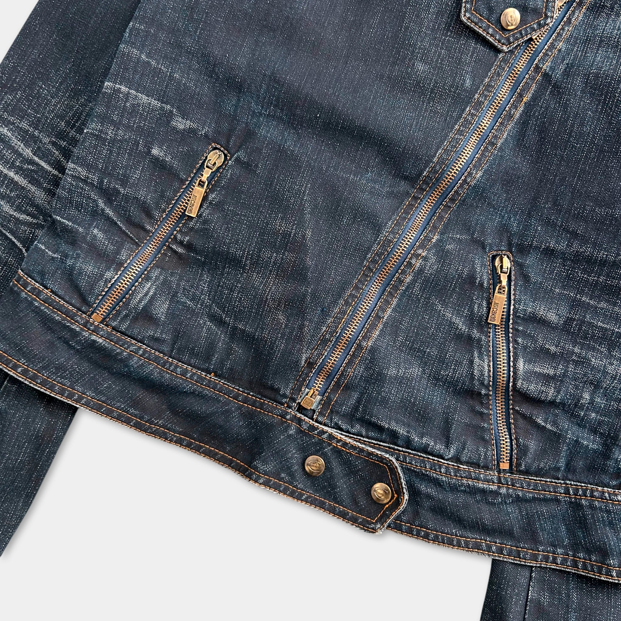 A close-up view of a dark blue denim jacket with gold zipper details.