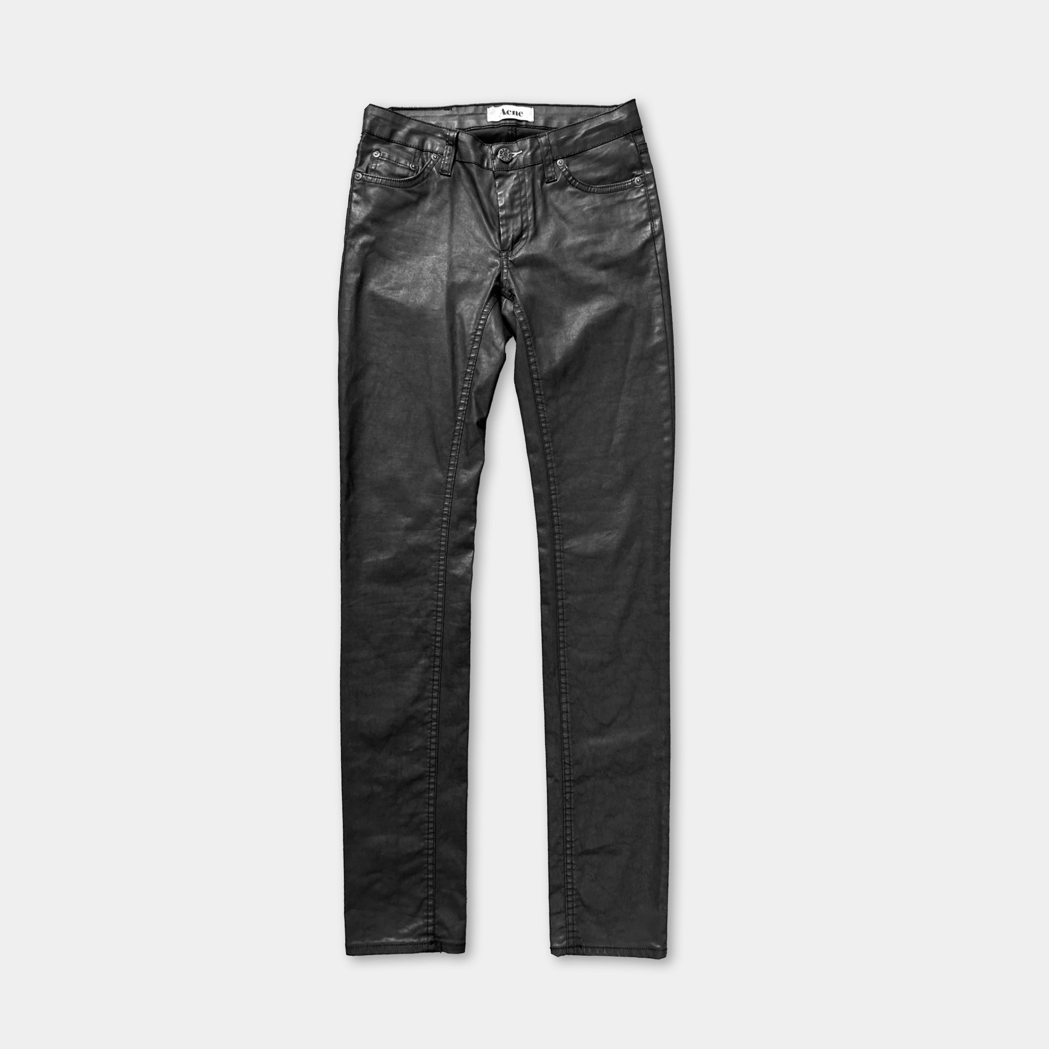 A pair of black leather jeans against a white background.