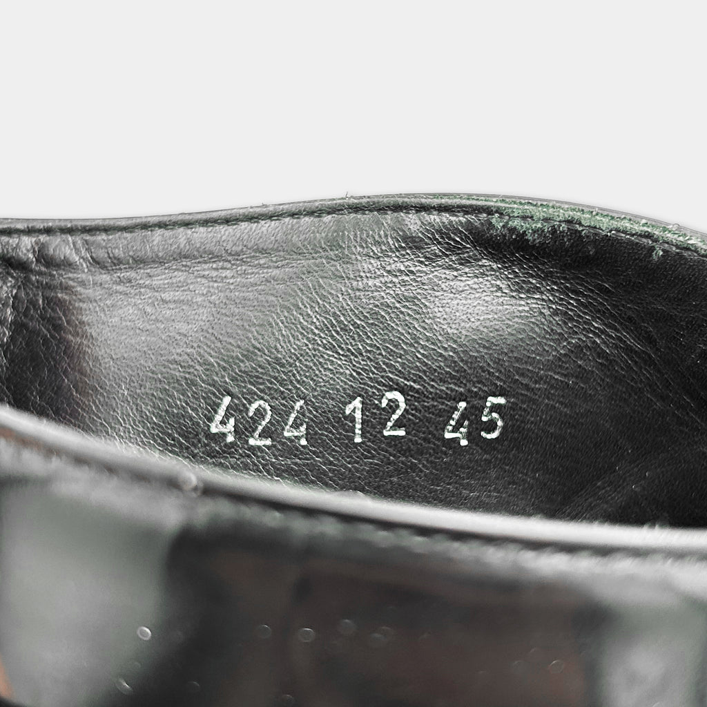 the interior of a black leather shoe, with the numbers "422 12 45" printed on the inside of the shoe.