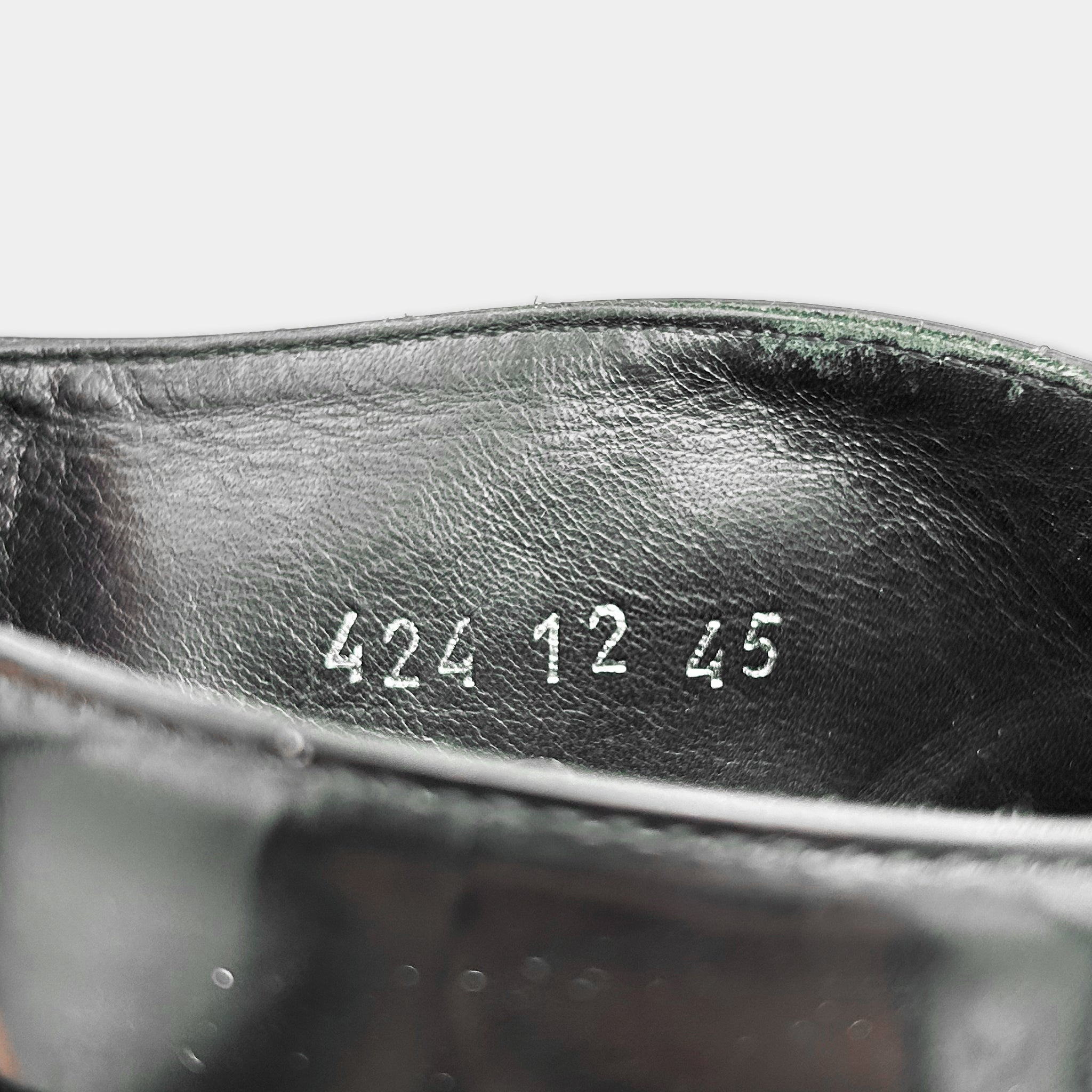 the interior of a black leather shoe, with the numbers "422 12 45" printed on the inside of the shoe.