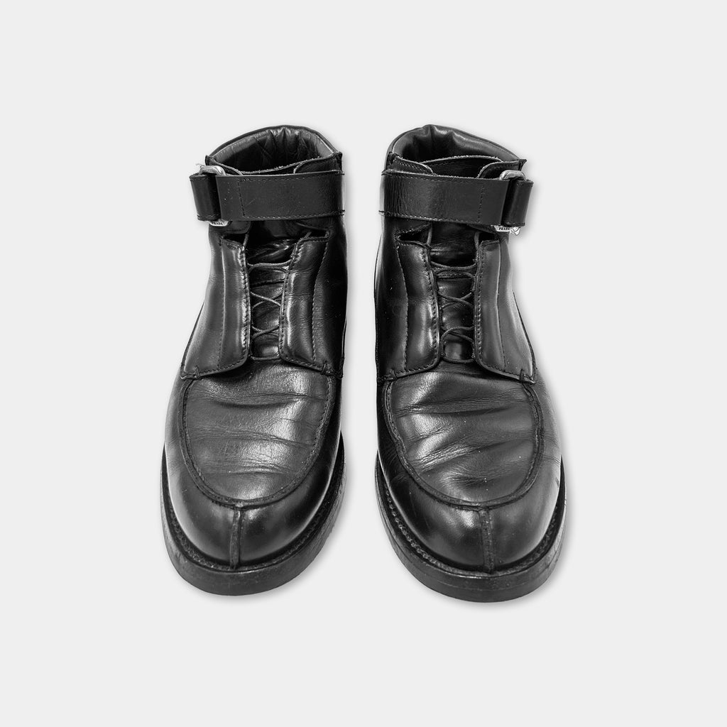 A pair of black leather boots with laces and buckles.