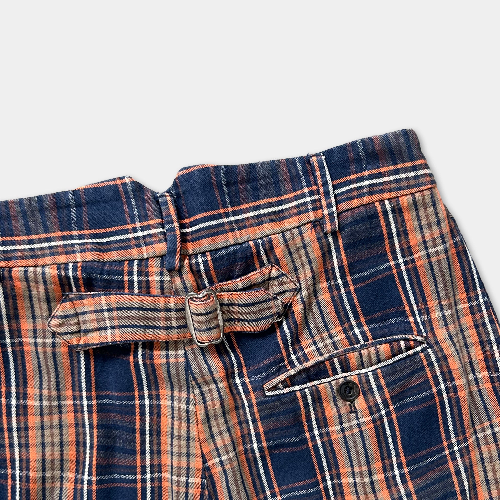 A pair of plaid trousers with a belt and a button.