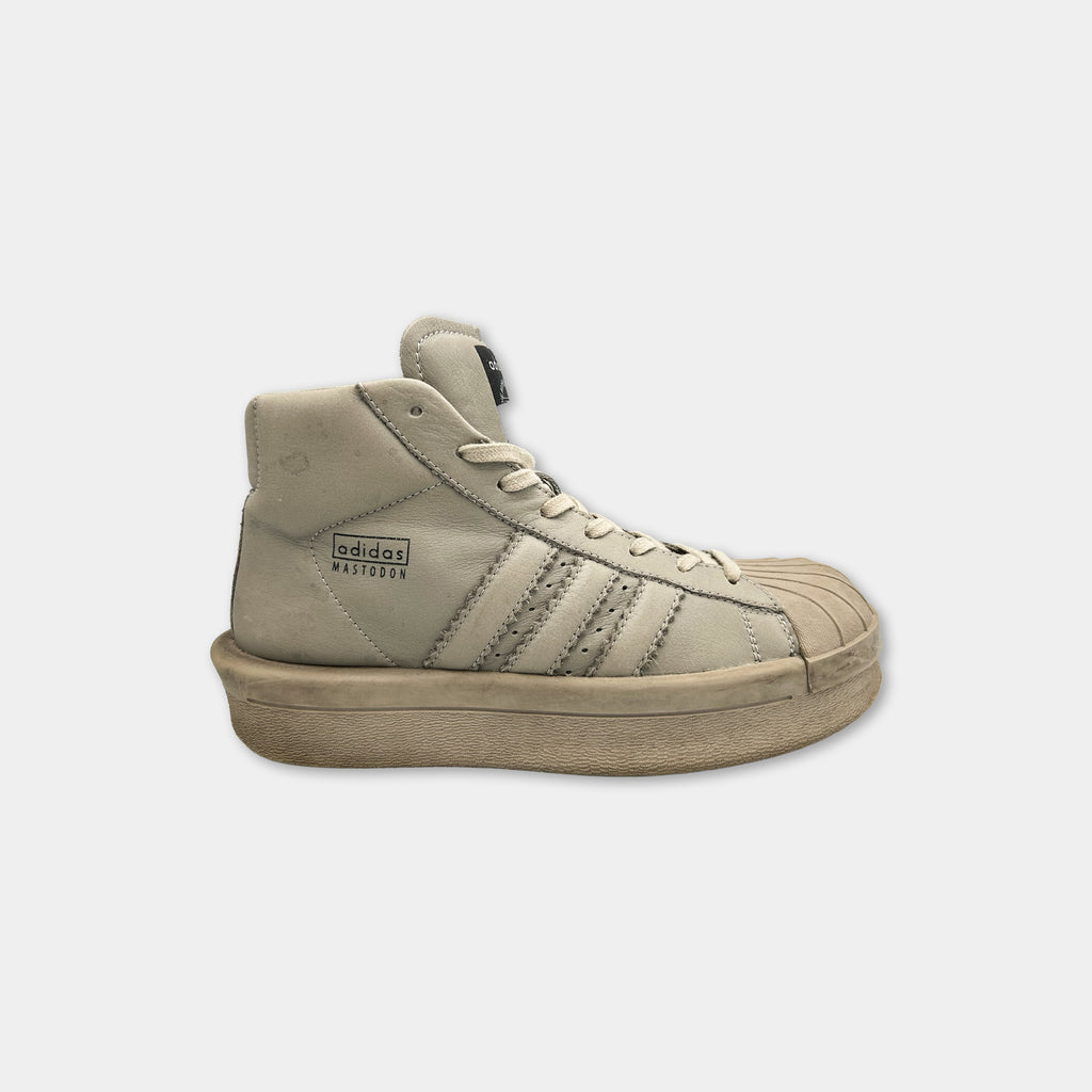 A tan Adidas sneaker with the brand name visible on the side.