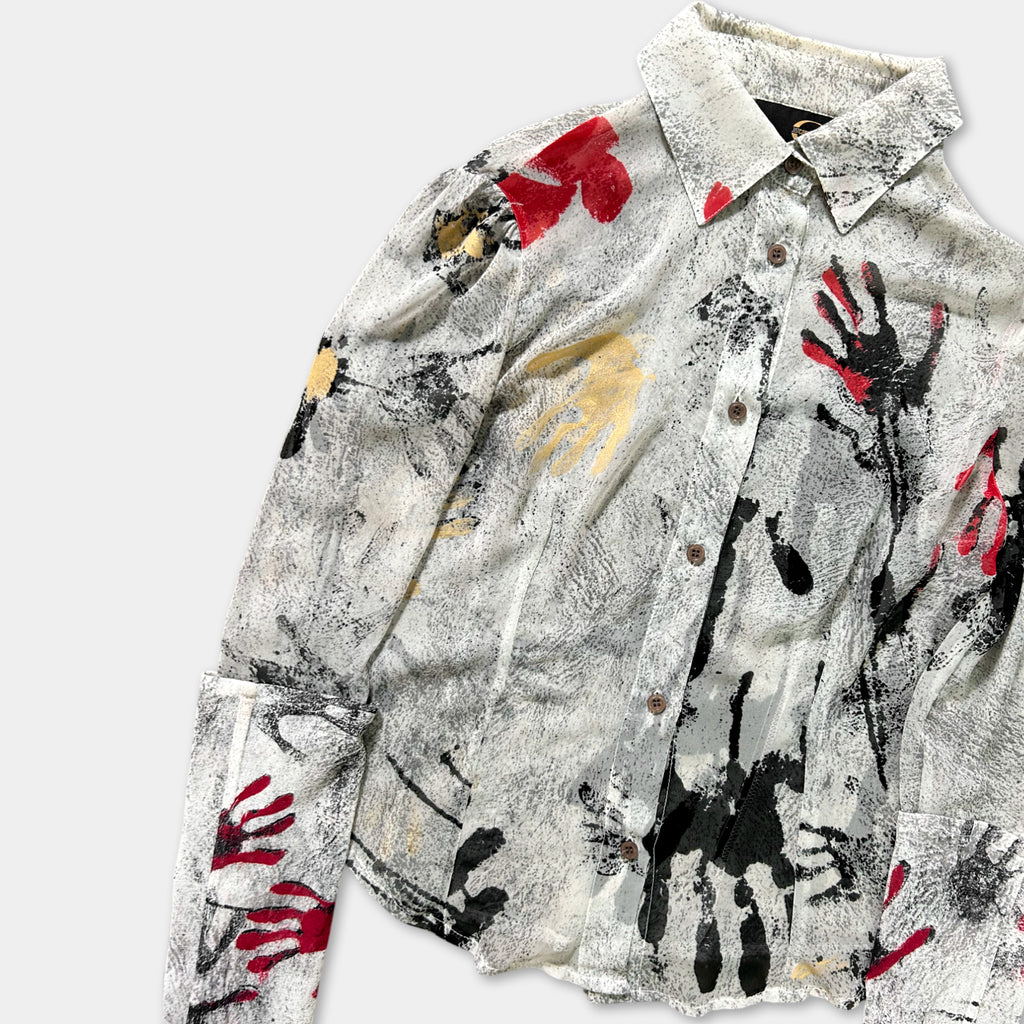 a white shirt with a black and red abstract print design on it.