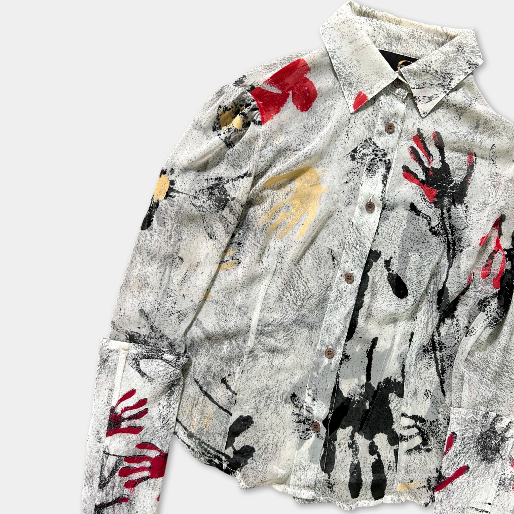 a white shirt with a black and red abstract print design on it.