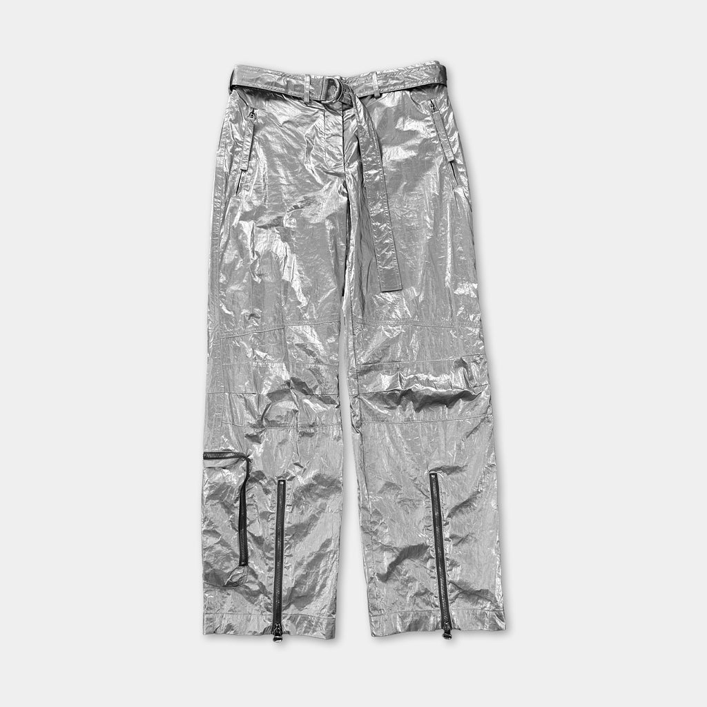 A pair of shiny silver pants with multiple zippers and pockets.