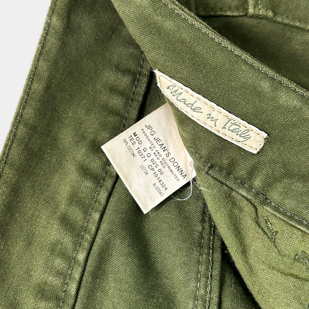 A close-up view of a green fabric, possibly denim, with a label attached to it. The label appears to be a tag or label, possibly indicating the brand or product information.