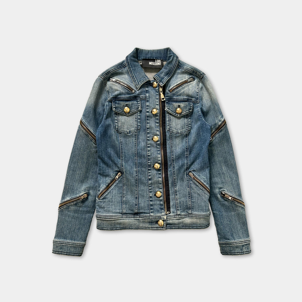 A denim jacket with multiple zippers and buttons, displayed against a plain background.