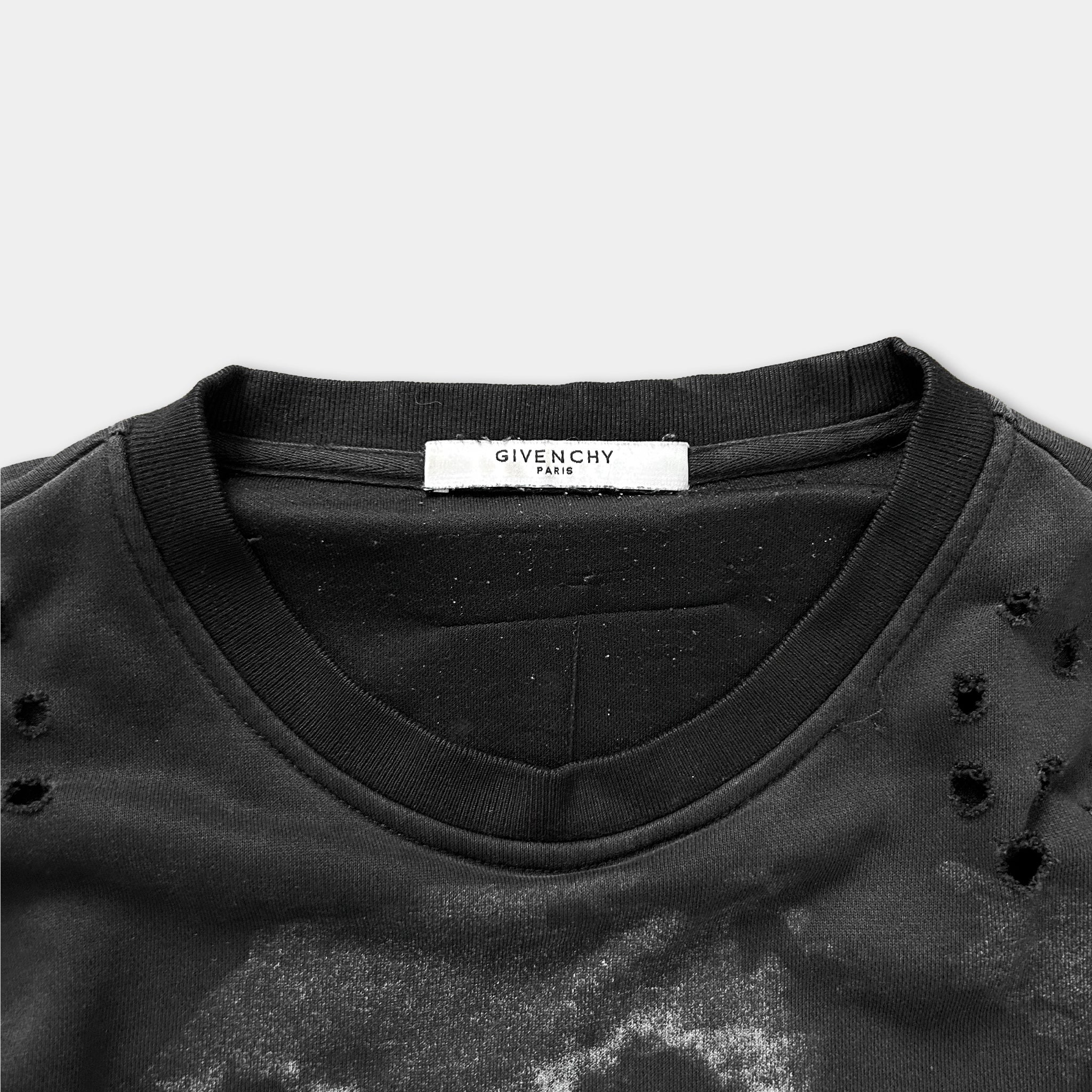 a close-up view of a black t-shirt with a label on the collar.