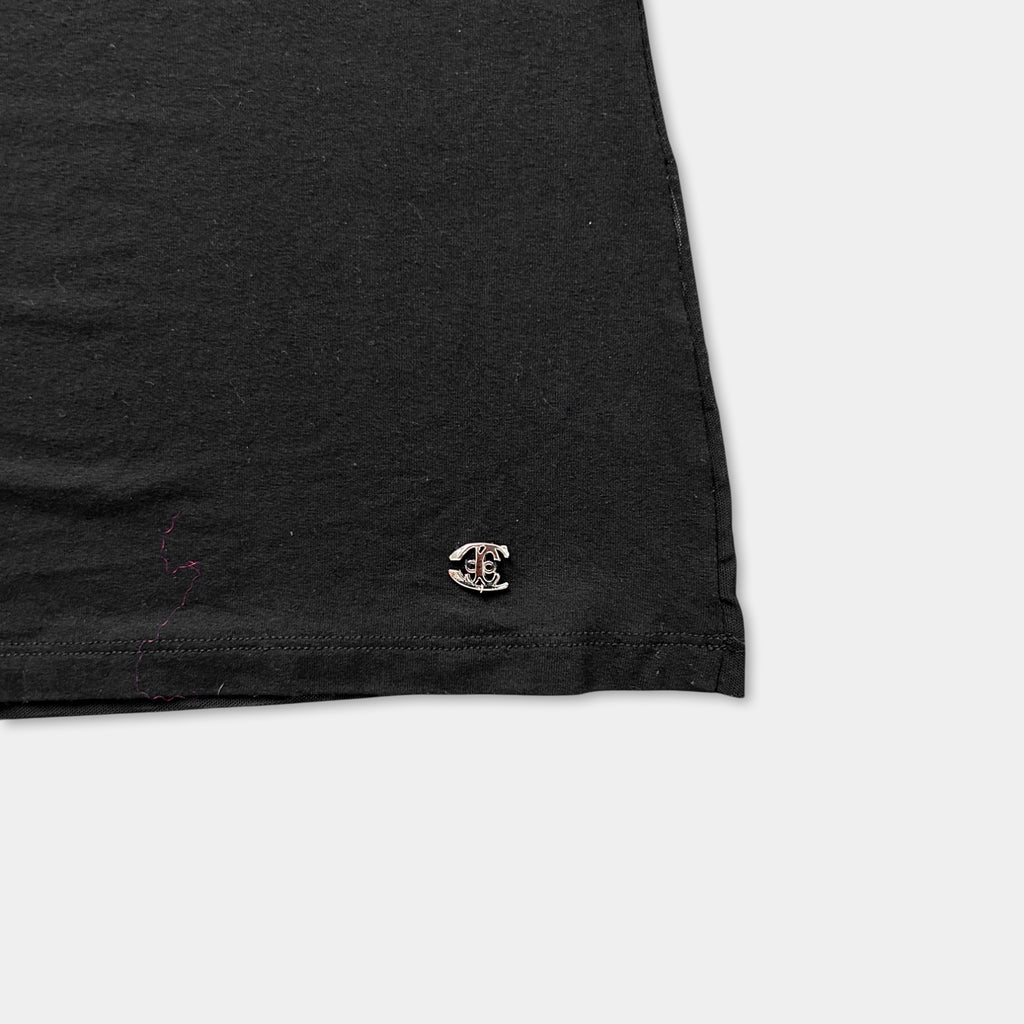 a close-up view of a black fabric, possibly a shirt or garment, with a small logo or emblem visible on the edge.