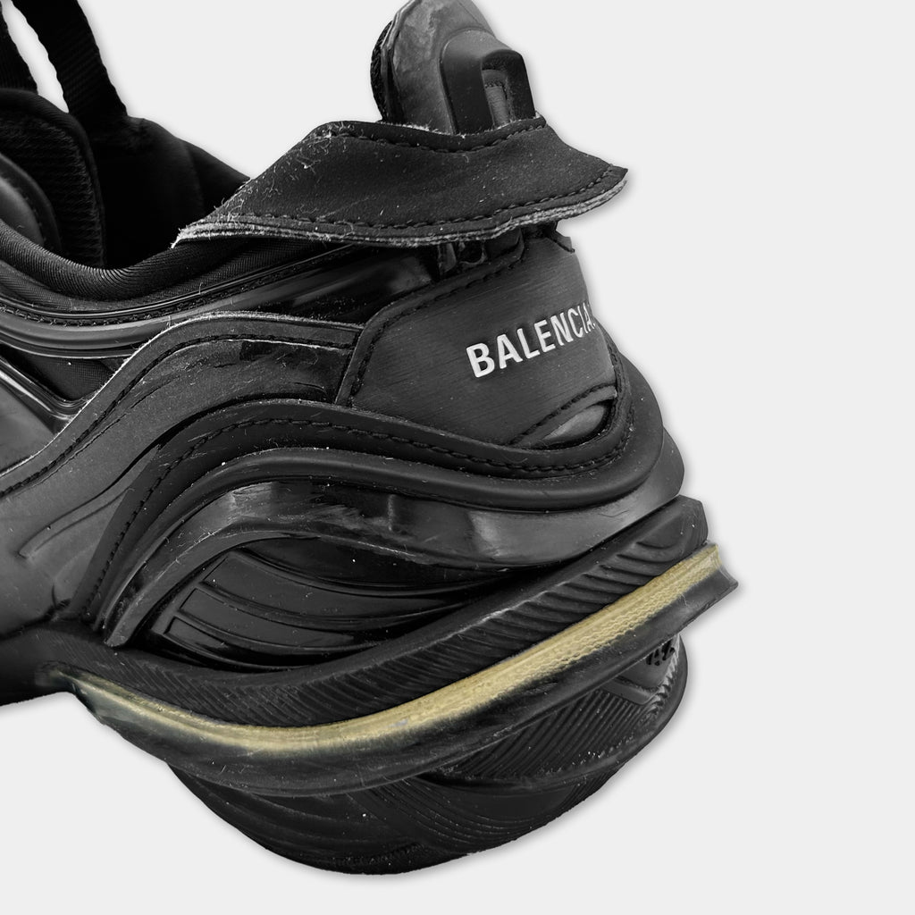 A close-up view of a black Balenciaga sneaker, showing the upper part of the shoe and the sole.