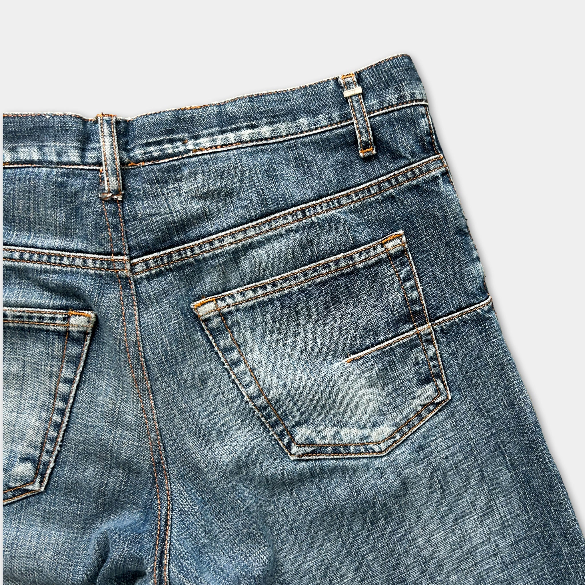 a close-up view of a pair of blue jeans, focusing on the back pocket and the zipper.