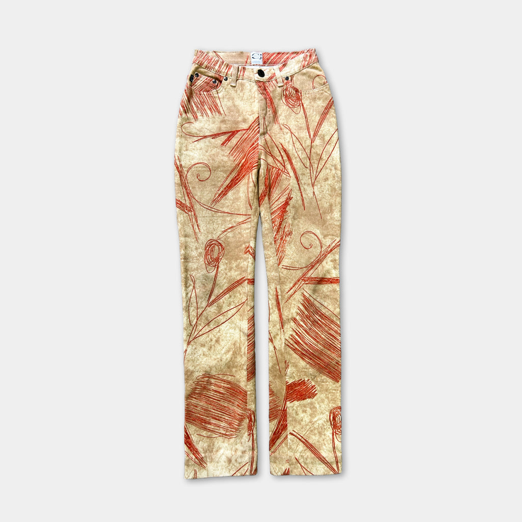 A pair of high-waisted, beige-colored jeans with a floral print pattern.