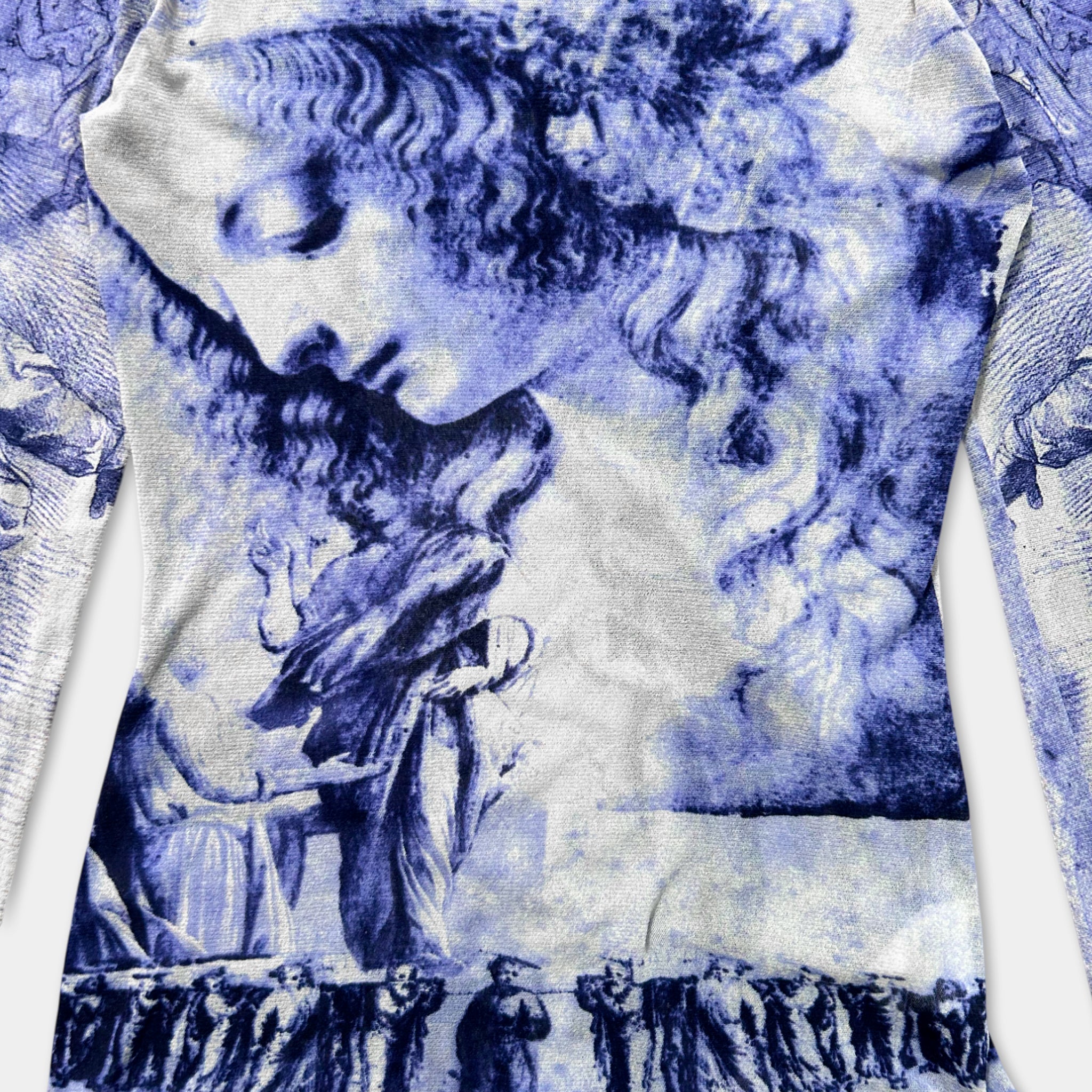 The image is a close-up of a fabric with a blue and white printed design featuring a stylized human face.