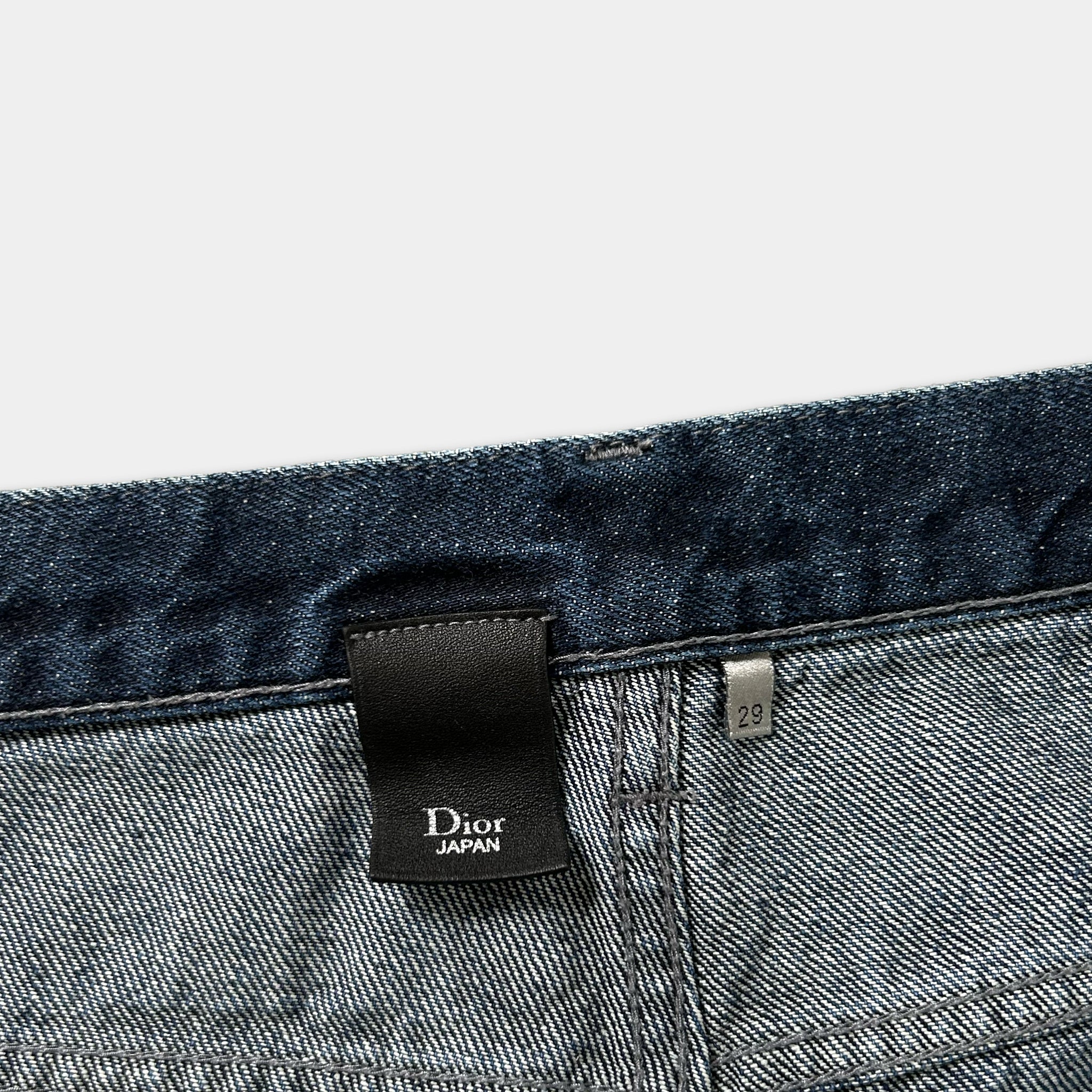 a close-up view of a pair of blue denim jeans, with a black label attached to the waistband.