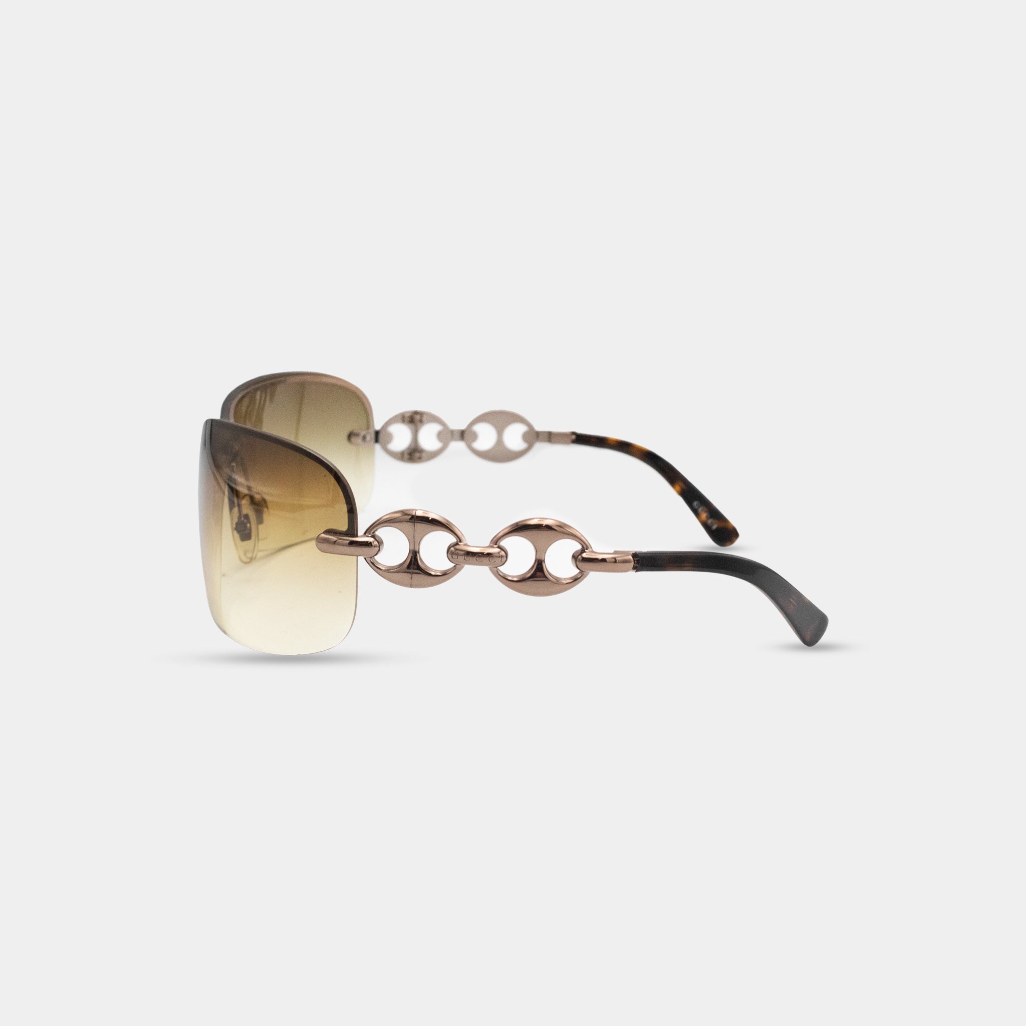 A pair of stylish sunglasses with a gold-tone frame and black temples.
