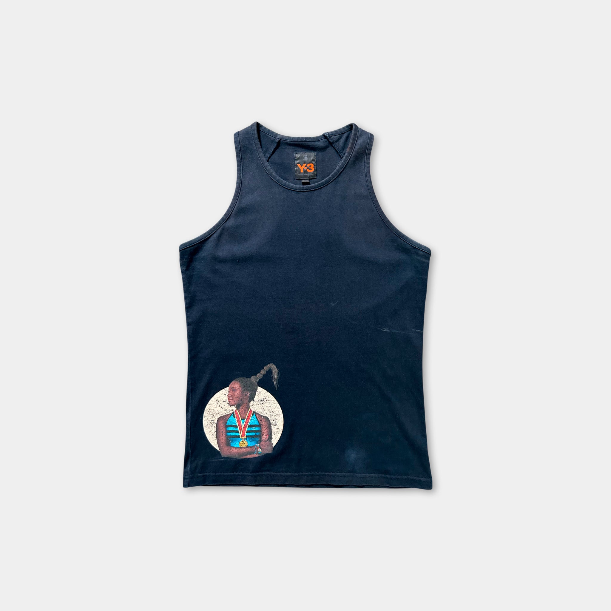 The image is a navy blue tank top with a graphic design on the front, depicting a person with a headdress.