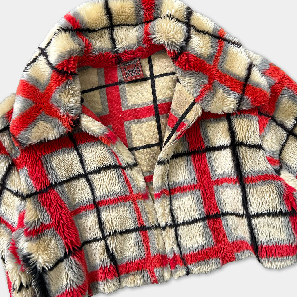 A close-up image of a red and white plaid jacket with a collar and zipper.