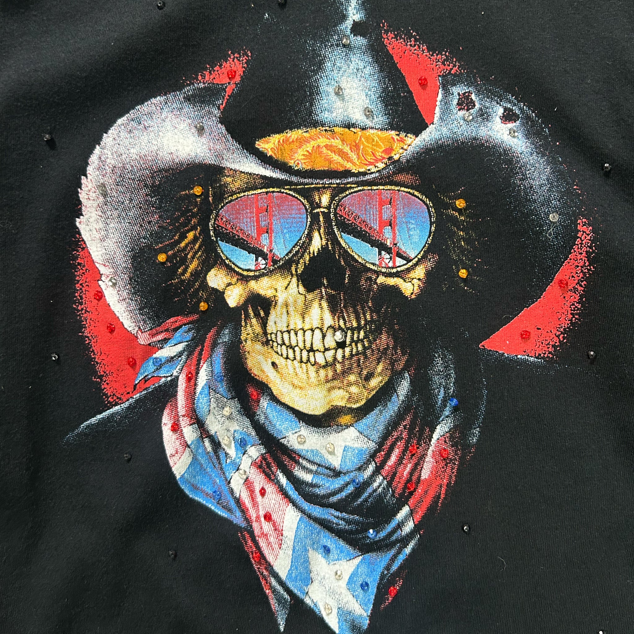 A skull wearing sunglasses and a cowboy hat with a bridge reflection, set against a black background with red and white accents.