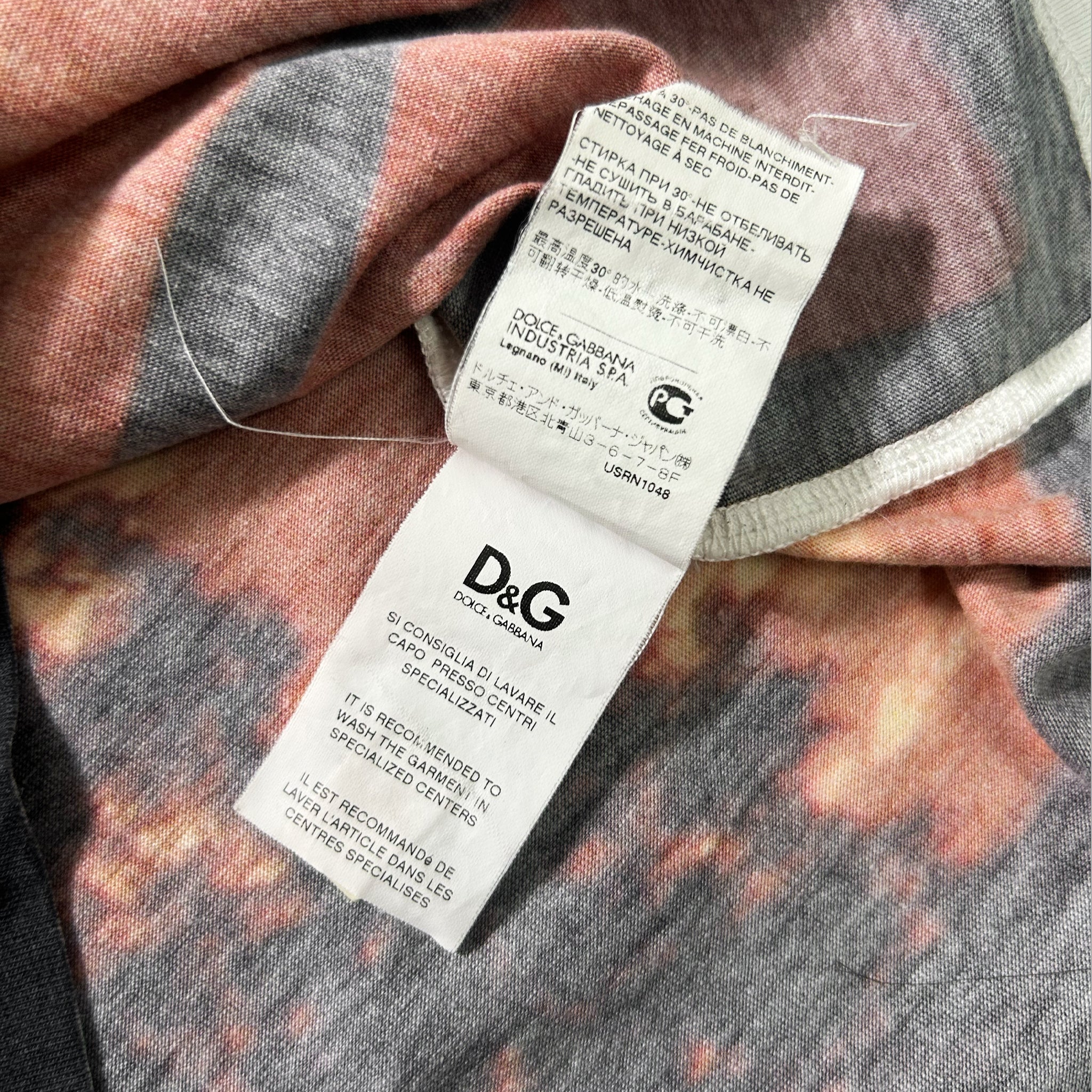 a close-up view of a fabric label from a clothing item, with a patterned fabric visible underneath.