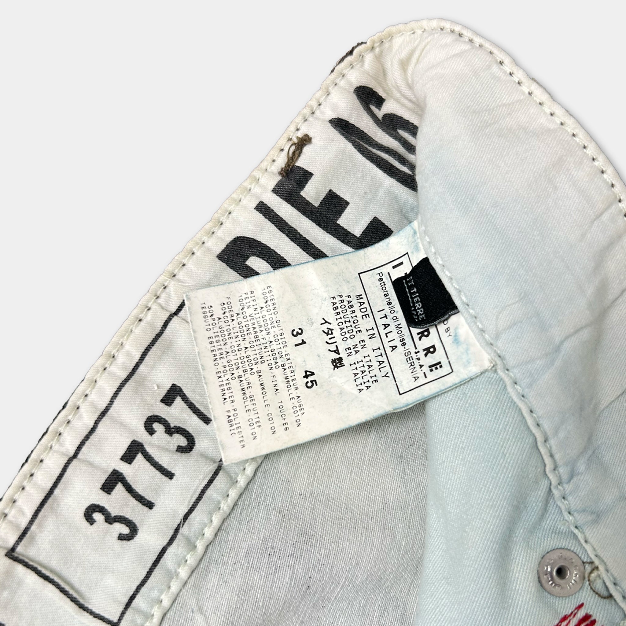 a close-up view of a white fabric, possibly a piece of clothing, with a label attached to it. The label appears to contain text and numbers, but the image does not contain any text that can be transcribed within the given word count limitations.
