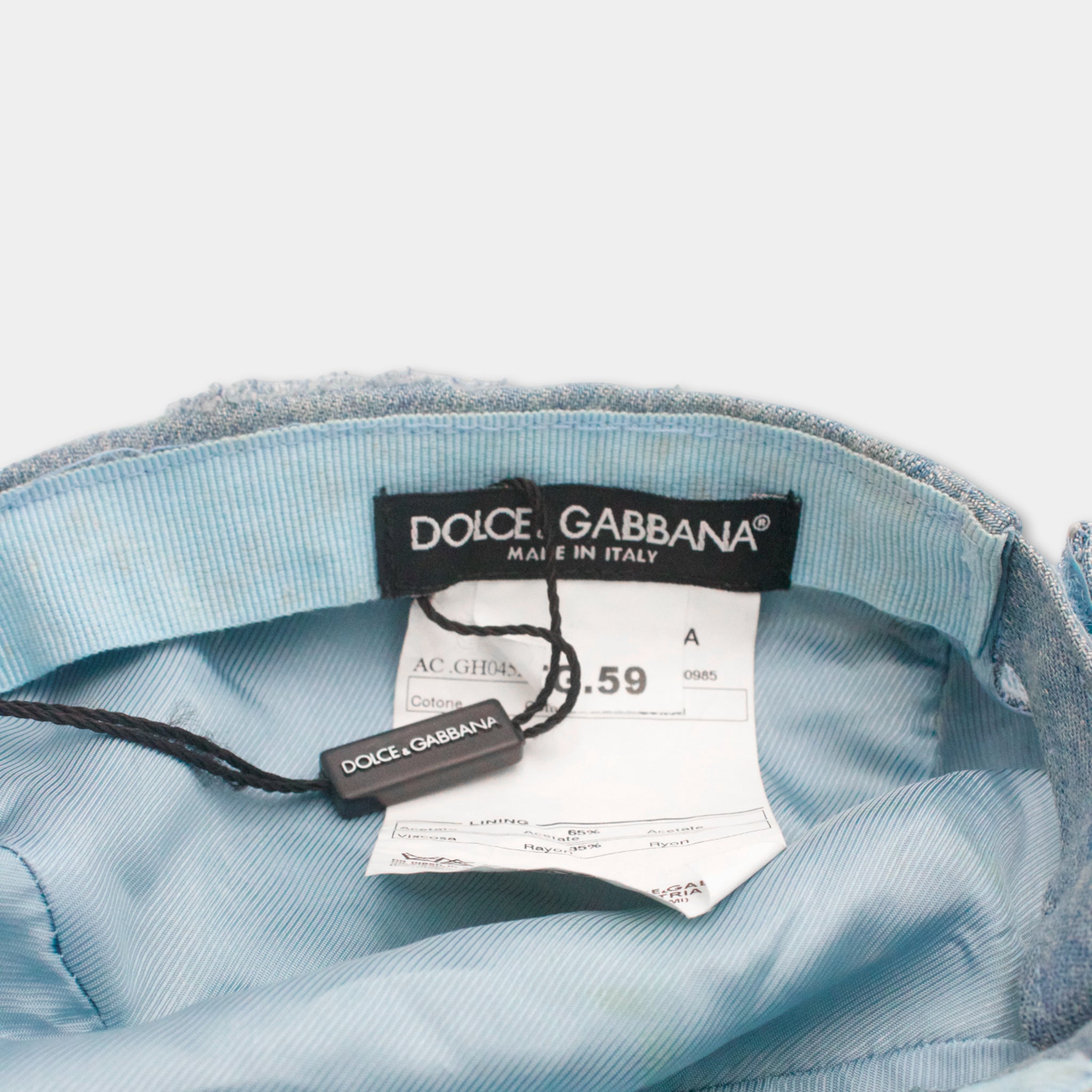 a close-up view of a blue denim jacket with a tag attached to it, indicating that it is a product of the Dolce & Gabbana brand.