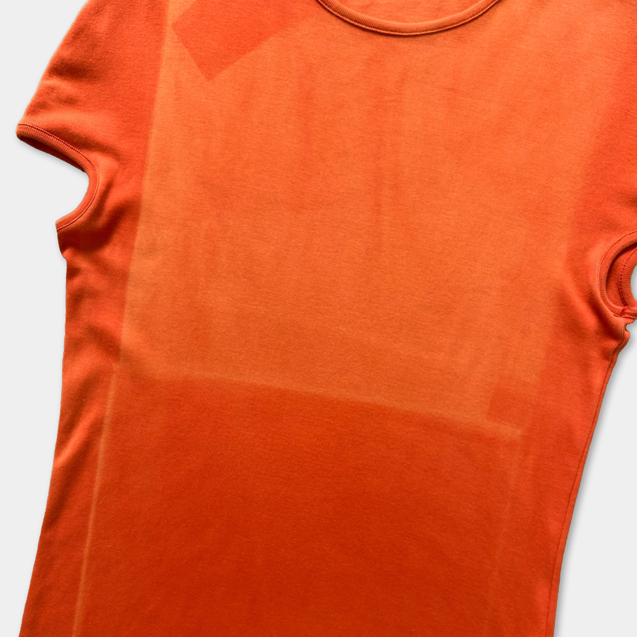 a bright orange t-shirt with a noticeable stain on the left side.