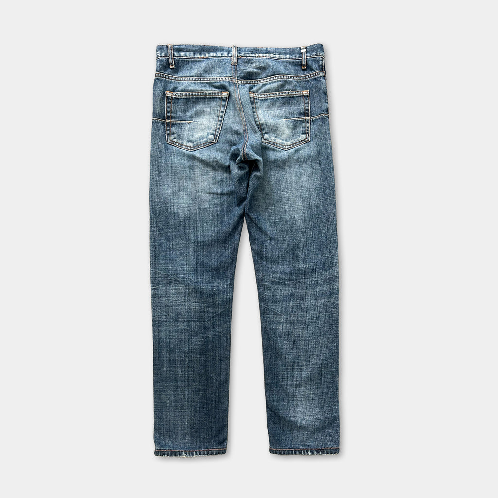 A pair of blue jeans with a classic design, featuring a pocket on the back and a zipper closure.