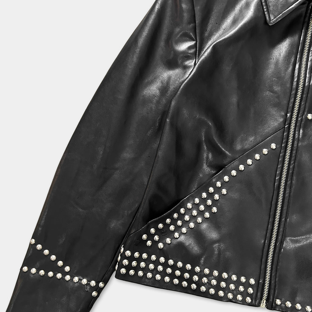 A close-up view of a black leather jacket with silver studs on the sleeves and collar.
