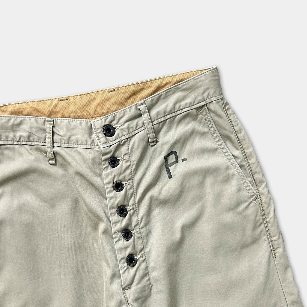 A pair of khaki cargo shorts with a button closure and a logo on the waistband.