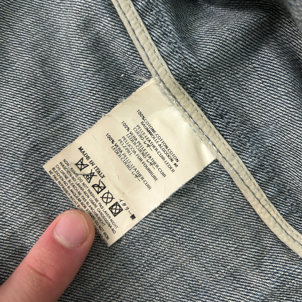 A close-up view of a denim fabric, with a label attached to it. The label appears to contain text and symbols related to the care and maintenance of the fabric.