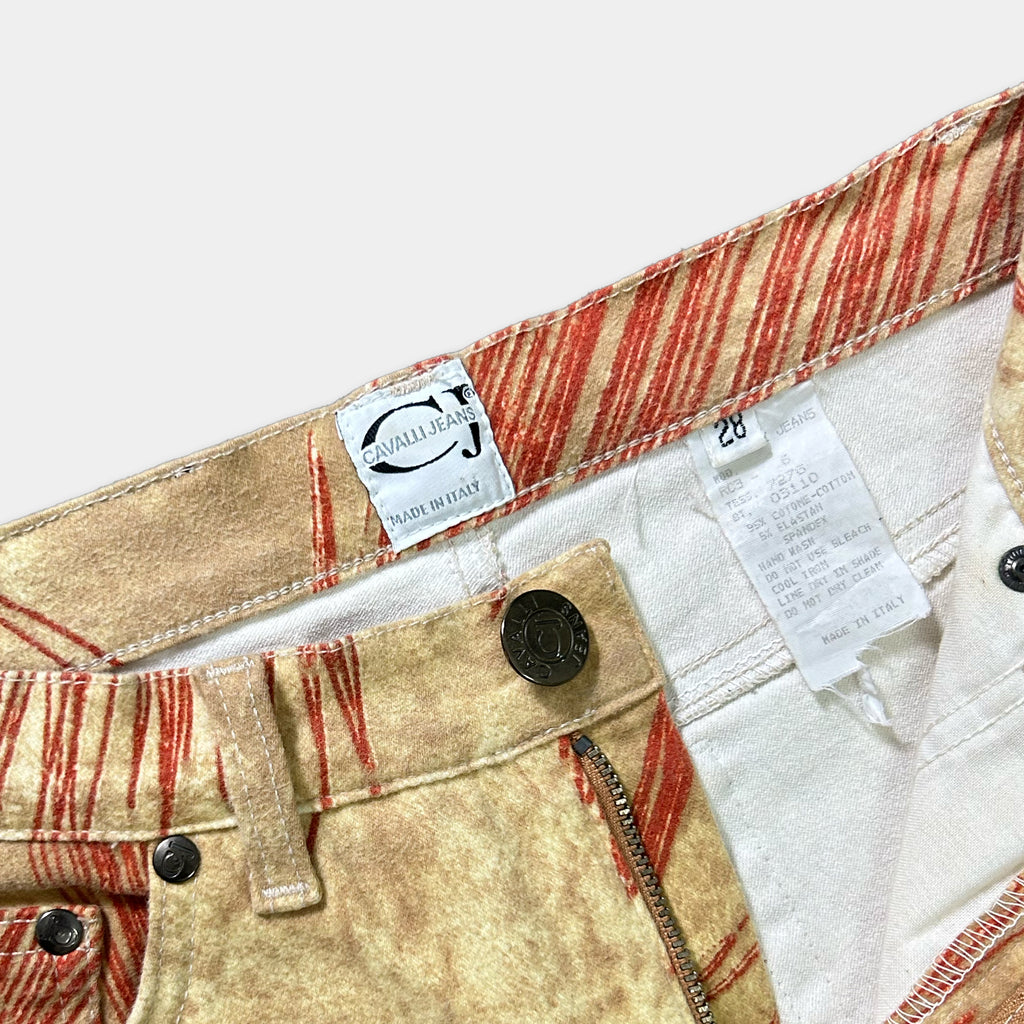 a pair of beige and red patterned jeans with a label and tag attached to the waistband.