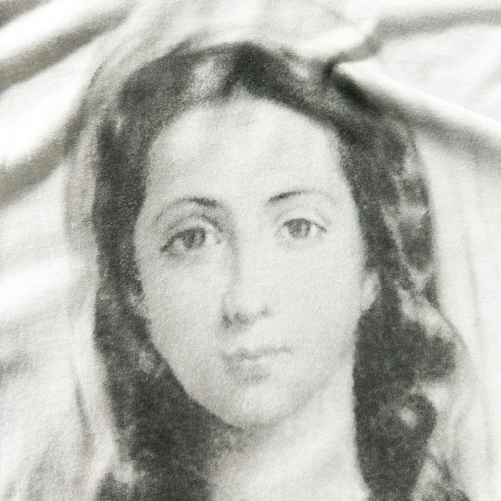 A black and white portrait of a woman with long hair, her face and upper body prominently featured.
