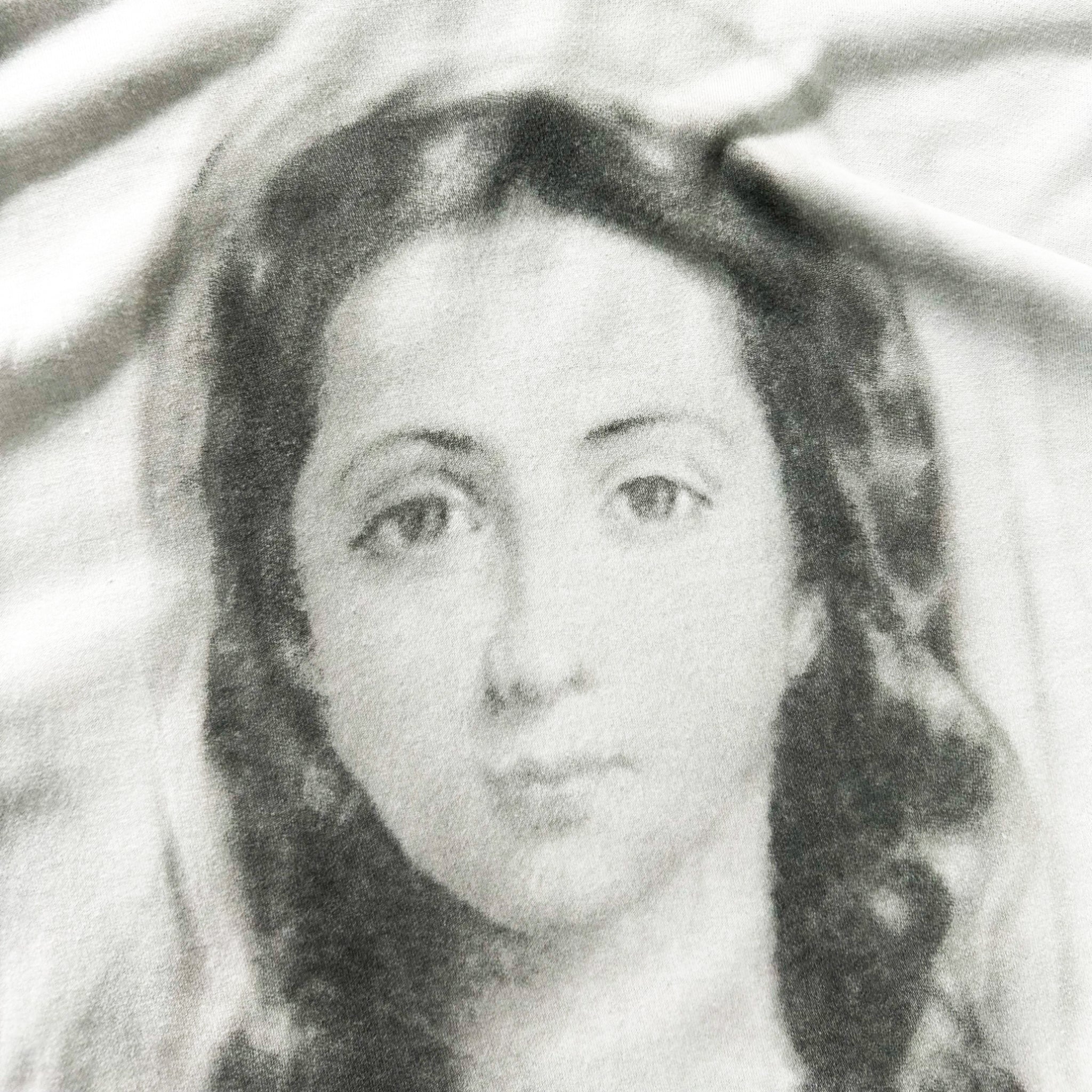 A black and white portrait of a woman with long hair, her face and upper body prominently featured.