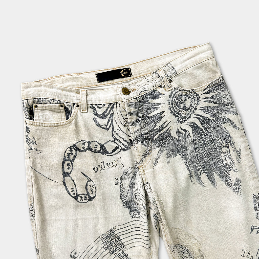 a pair of beige jeans with a unique, intricate design featuring a snake and various other patterns.