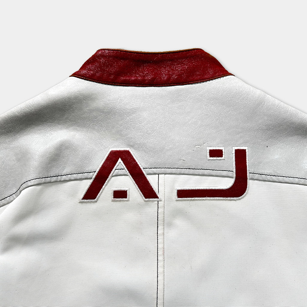 a close-up view of a white jacket with a red collar and a red logo on the back.