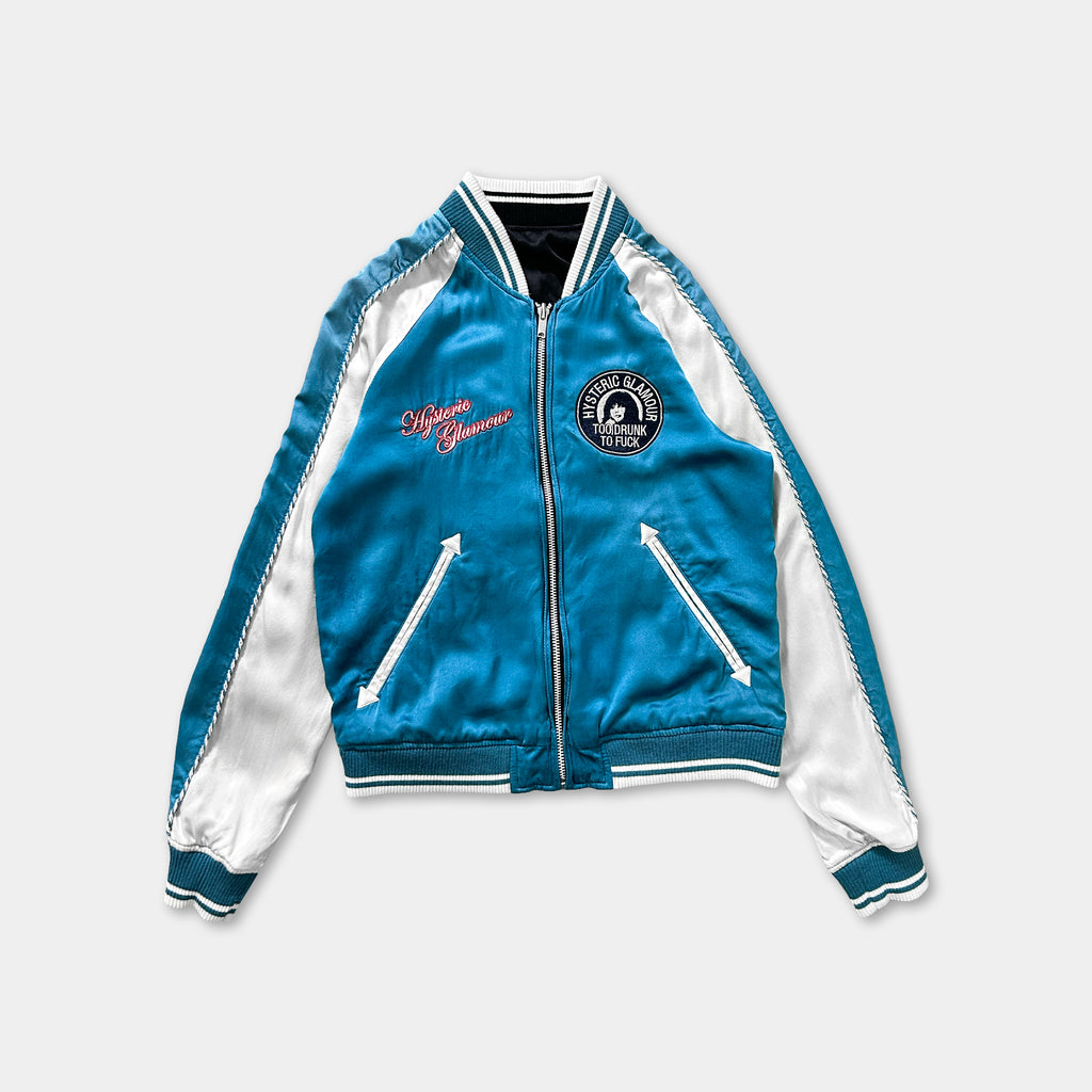 A blue and white jacket with a zipper and pockets, featuring a logo on the left side.