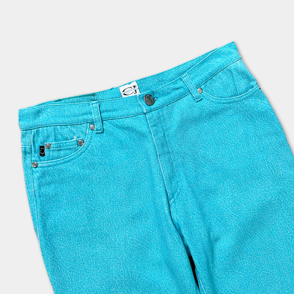 A pair of bright turquoise blue jeans with a white label on the waistband.