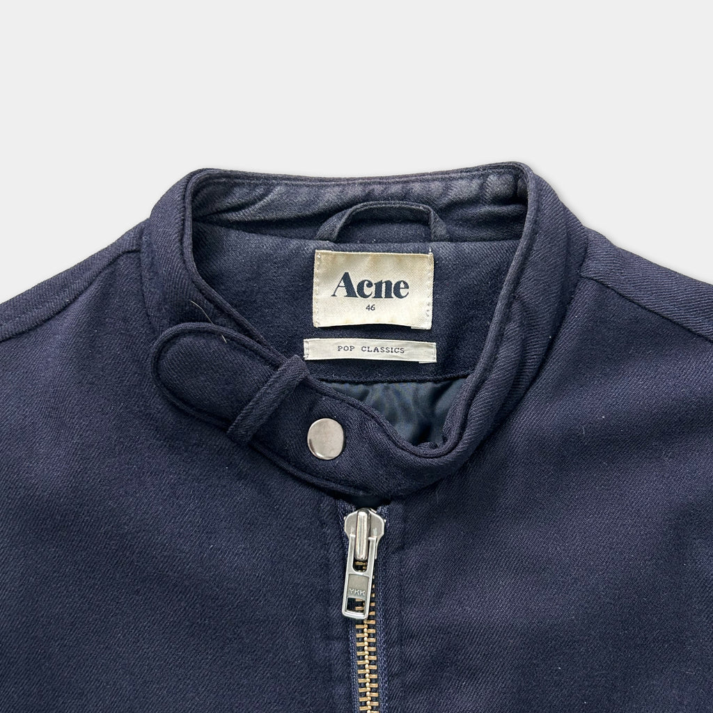 A navy blue jacket with a zipper and a label on the collar.