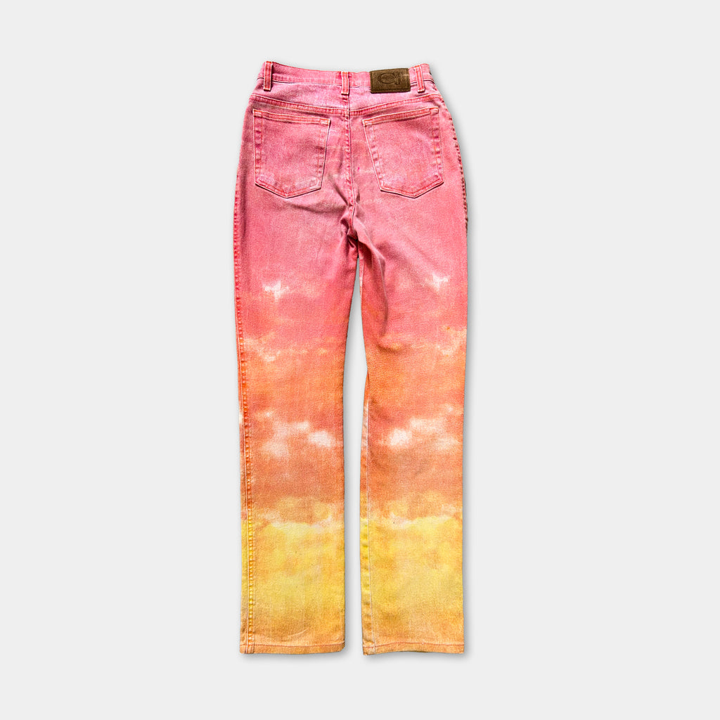A pair of pink and yellow tie-dye jeans with a cloud-like pattern.