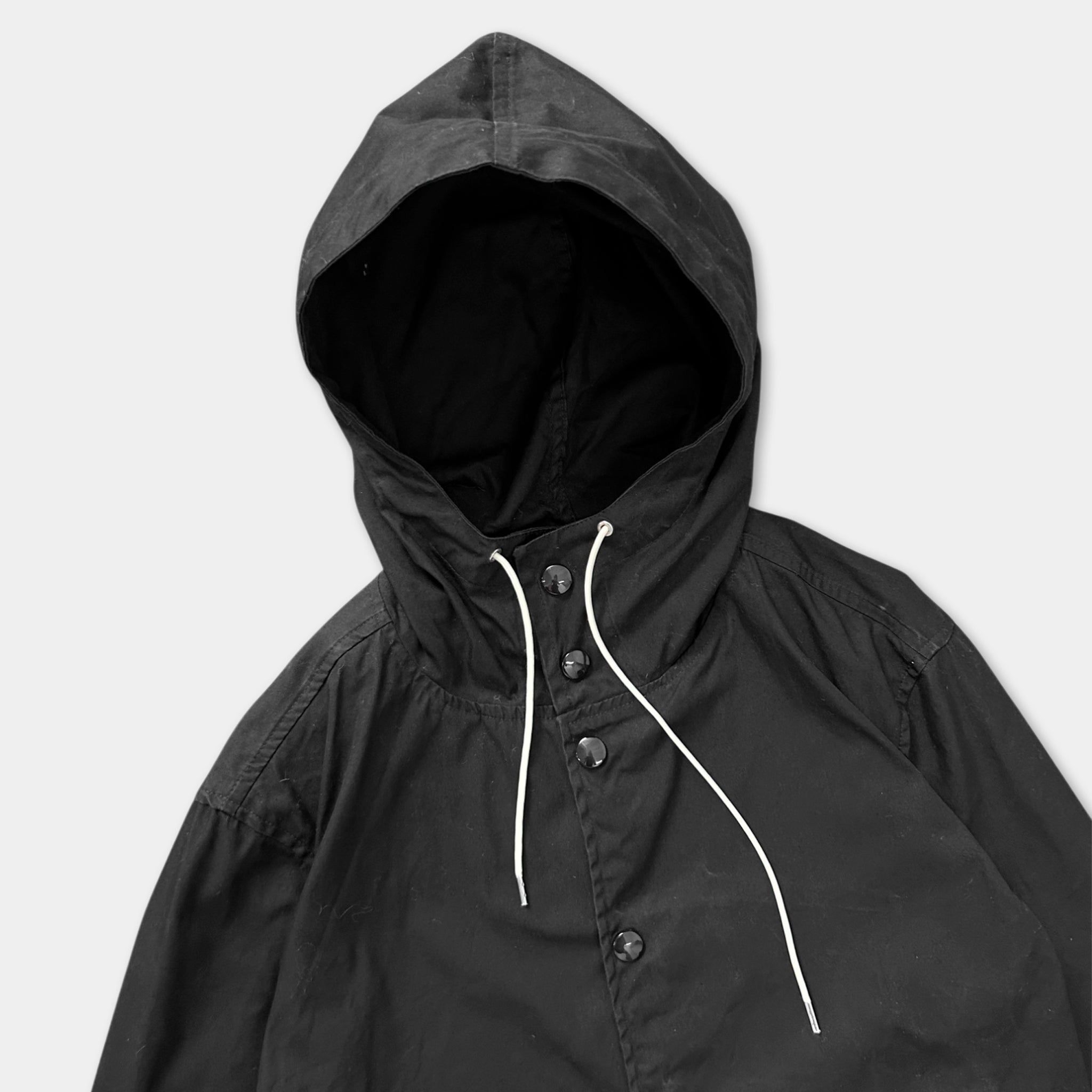 A black hooded jacket with white strings hanging down.