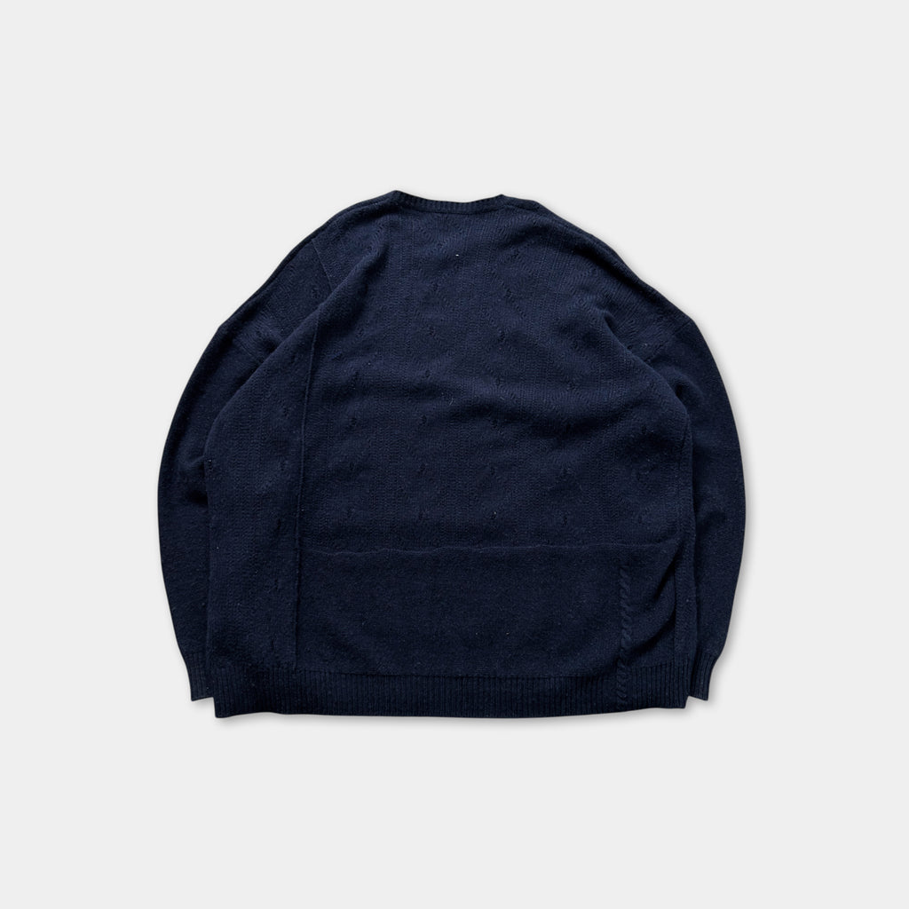 A navy blue sweater is shown against a white background.