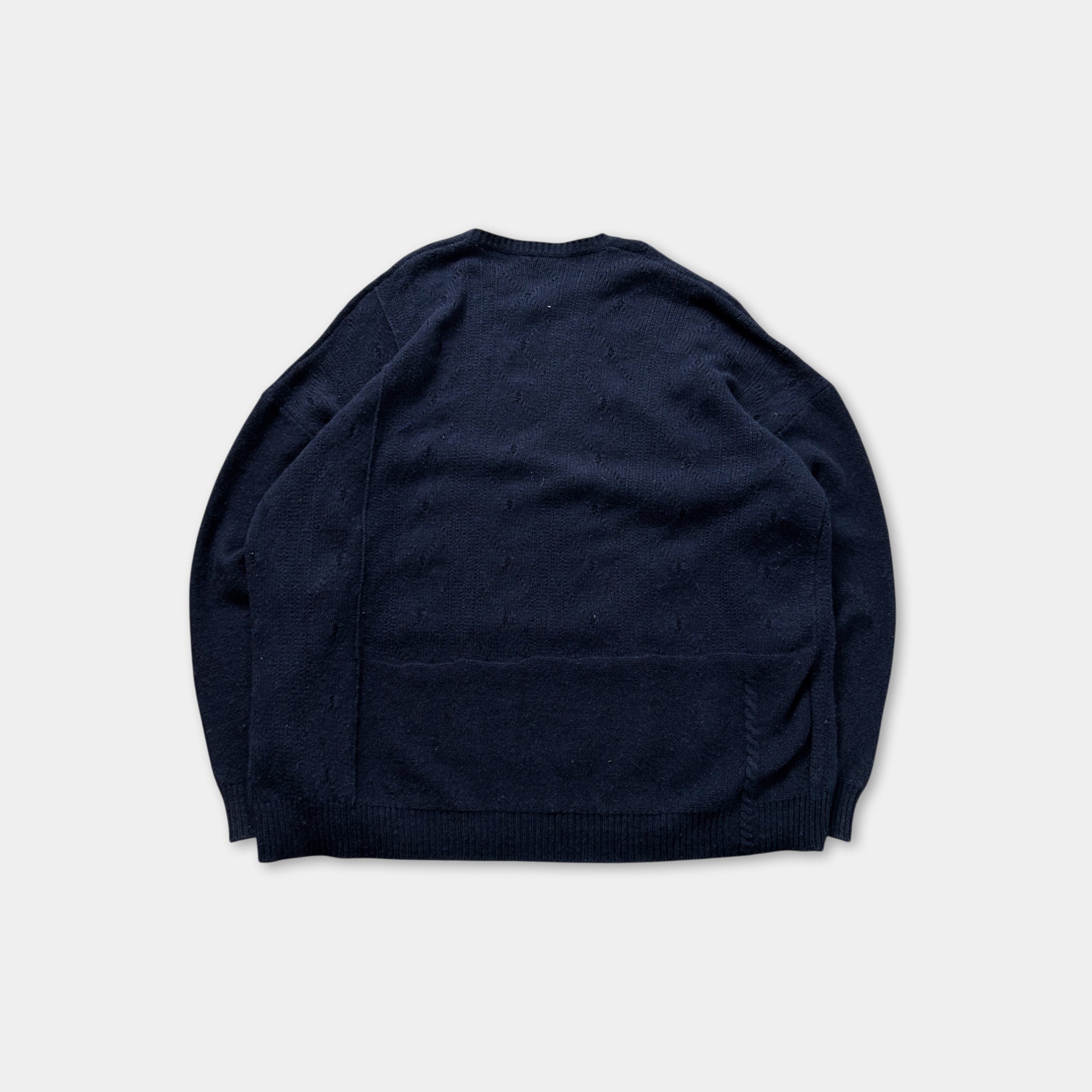 A navy blue sweater is shown against a white background.