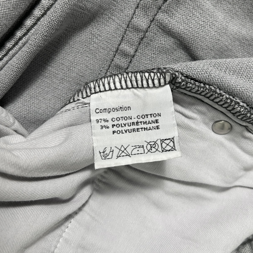 a close-up view of a label on a piece of clothing, likely a garment or textile. The label provides information about the composition of the fabric, including the percentage of cotton, polyurethane, and other materials used.