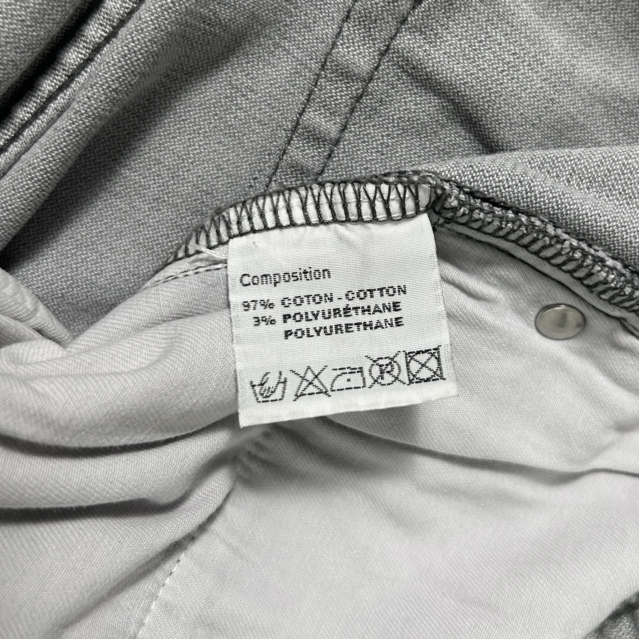 a close-up view of a label on a piece of clothing, likely a garment or textile. The label provides information about the composition of the fabric, including the percentage of cotton, polyurethane, and other materials used.